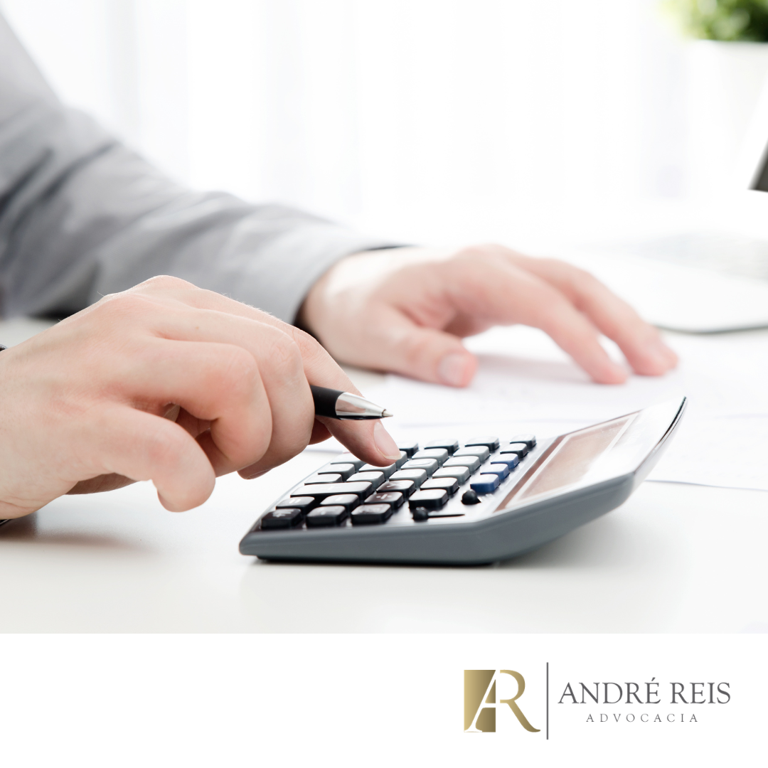 Advogado calculando custos de inventário em Praia Grande SP utilizando calculadora e documentos sobre mesa de escritório.